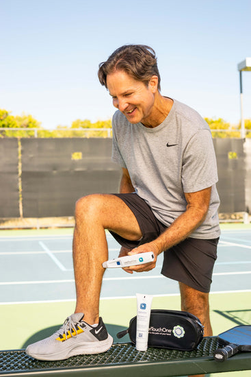 Photo of a man using a Laser Touch One cold laser therapy device on his calf muscle